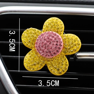 Macro shot of 3.5cm rhinestone flower car vent clip with yellow petals and pink center