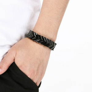 Close-up of black V-shaped snake bone stainless steel bracelet on a model's wrist