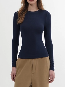 Detail of navy blue slim fit long sleeve crew neck top on model with clean background
