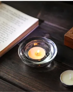 Draufsicht auf minimalistischen Kerzenhalter aus Kristallglas mit brennendem Teelicht