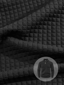 Macro shot of black waffle knit fabric texture on long sleeve men sweatshirt with collar