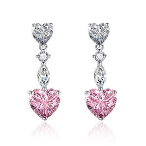 Dettaglio di orecchini pendenti con zircone rosa a cuore, finitura argento e taglio brillante