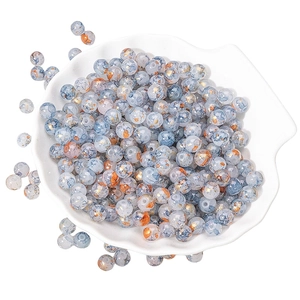 Ink-wash style 8-10mm glass beads with gold foil textures in a white shell dish