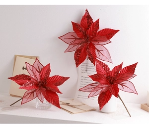 Detailed view of red artificial poinsettia with glitter petals and decorative stems