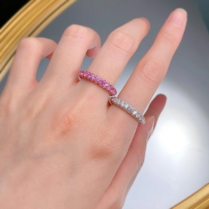 Close-up of sparkling pink and white micro-pave eternity rings on a model's hand
