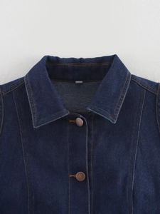 Gros plan détaillé du col en denim bleu foncé avec coutures contrastées et boutons