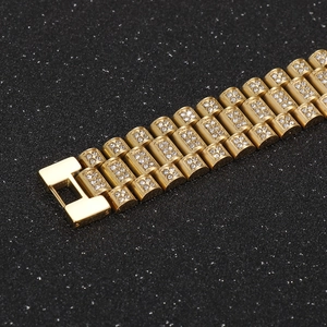 Macro view of gold-tone hip hop bracelet featuring pave-set rhinestones and a folding clasp