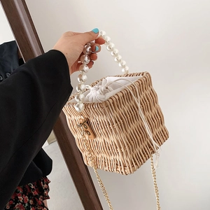 Handcrafted woven straw handbag with large pearl handle and golden chain strap for summer