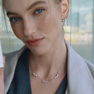 Elegant stainless steel necklace and earring set with zircon accents on a model