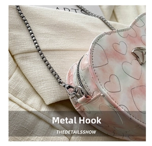 Close-up of durable silver metal chain hooks and texture on pink heart-shaped bag