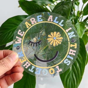 Rainbow suncatcher window film with 'We Are All In This Together' text and laser texture
