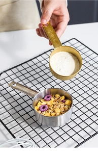 Detail of stainless steel measuring cups with engraved scale 1/4 and 1/3 cup sizes