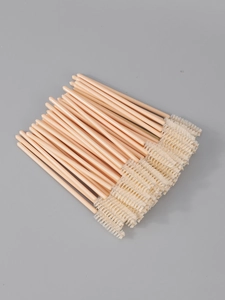 Flat lay of 50 disposable mascara wands with pink handles and white spiral bristles