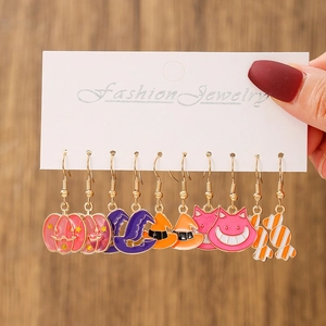 Close-up of Halloween earrings set featuring pumpkin, cat and wizard hat designs