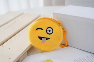 Mini plush coin purse featuring a yellow winking face with embroidery on a wooden surface