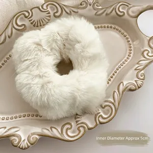Close-up of white plush scrunchie with a 5cm inner diameter on a vintage tray