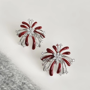 Detailaufnahme von silbernen Blumenohrringen mit roter Emaille und Zirkonia-Akzenten