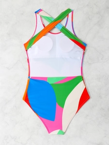 Flat lay of colorful geometric patchwork one-piece swimsuit with cross-back straps