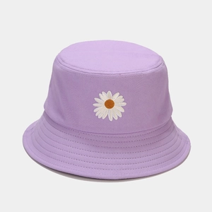Close-up of a lavender cotton bucket hat featuring detailed white daisy embroidery