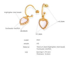 Detailed view of titanium steel gold earrings with heart shell and rose engraving