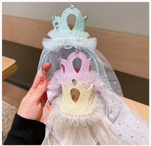 Detail of three sparkling princess crowns with starry tulle veils for girls' hair