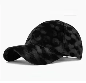 Close-up of black corduroy baseball cap with velvet polka dot patterns and texture