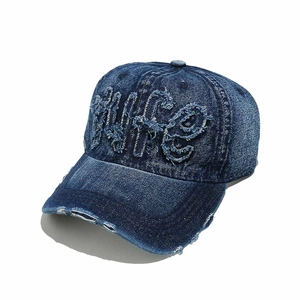 Detail of WIFE embroidery on distressed navy denim baseball cap with worn brim