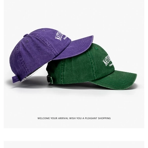 Dettaglio di cappellini da baseball vintage in cotone viola e verde con ricamo natura