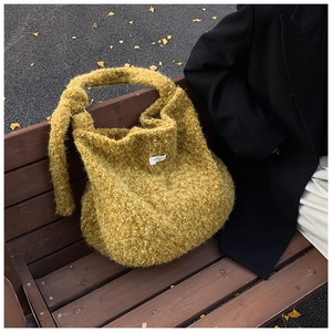 Detail of mustard yellow fuzzy tote bag with plush wool-like texture and knotted strap