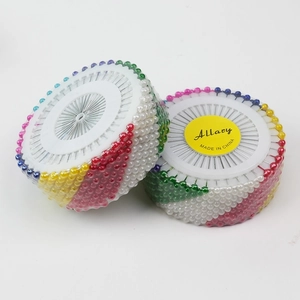 Close-up of multicolored pearl head sewing pins neatly arranged in round wheel discs