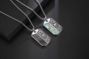 Close-up of titanium steel skull pendants with colorful shell and black finish inlay
