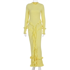 Détail d'une robe jaune en maille côtelée avec des volants élégants et des rubans longs