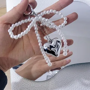 Cute pearl bow bag charm with silver heart pendant and lobster clasp attachment