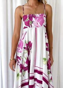 Detailed view of the white floral maxi dress featuring purple patterns and smooth fabric