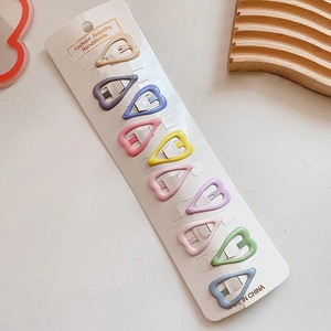 Close-up of ten colorful heart-shaped hair clips arranged on a white jewelry display card