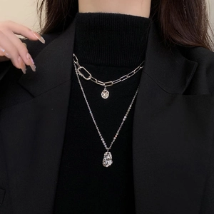 Detail view of double-layered silver OT buckle necklace with irregular geometric pendants