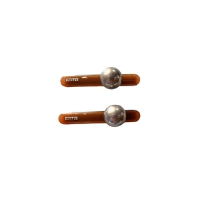 Brown resin fringe clips with silver metal studs and France engraving on white backdrop