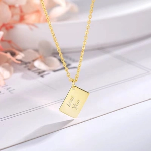 Close-up of golden envelope pendant engraved with Love You on a delicate chain