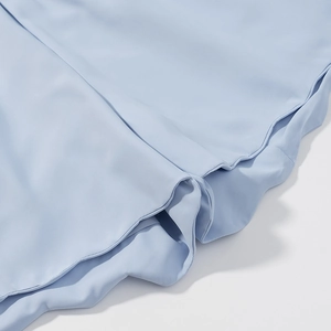 Detail view of light blue fabric texture with fine stitching and smooth finish