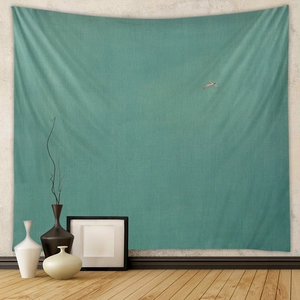 Detail of minimalist teal bohemian tapestry on white wall in a modern living room