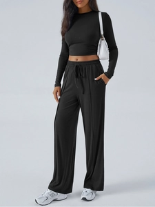 Women's black long sleeve crop top and wide-leg yoga pants set for athletic wear