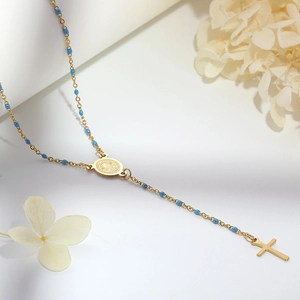 Detail of gold titanium steel Y-necklace with blue beads and Saint Benedict medal