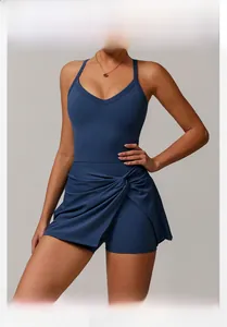Detail of navy blue tennis dress featuring V-neck cross straps and a twisted knot hem design