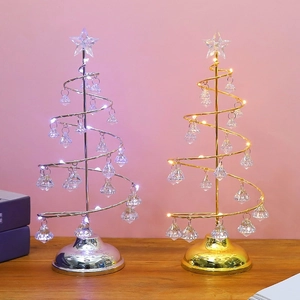 Close-up of golden and silver spiral metal Christmas trees with LED lights and crystals