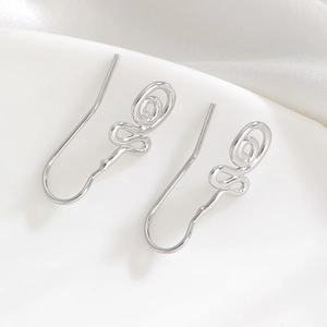 Detailed macro view of silver spiral ear cuffs with a delicate rose swirl design