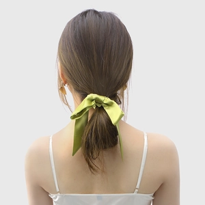 Grass green 100% mulberry silk bow scrunchie tied on a ponytail for elegant hair styling