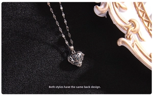 Macro view of silver heart hollow cage pendant with light blue bead on black background