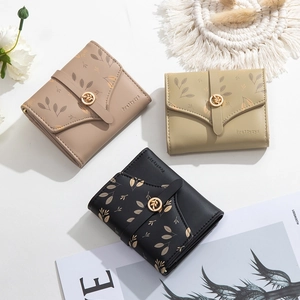 Detailed view of women's leather wallets with leaf prints and golden metal leaf buckle