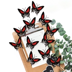Detail of 3D gold-stamped skull butterfly wall decals in red and black with floral patterns
