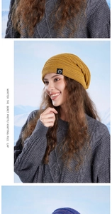 Detail of ginger yellow thick knit beanie with black mountain patch and ear protection